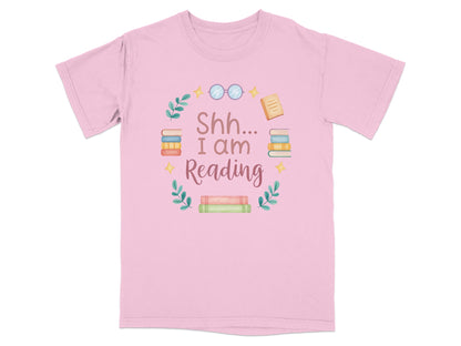 Pink t-shirt with "Shh... I am Reading" and stacks of books.