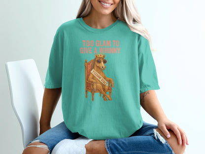 Woman wearing a teal t-shirt with "Too Glam to Give a Whinny" text and a crown.