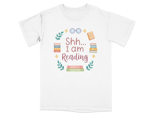 T-shirt with "Shh I am Reading" text and stacked books graphic.