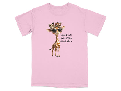 Pink t-shirt with a cartoon giraffe wearing sunglasses and a bow, text reads "Stand tall even if you stand alone".