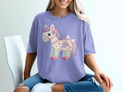 Purple t-shirt with a patchwork horse graphic and pink bow.