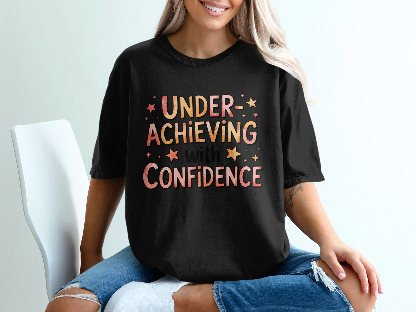 Black t-shirt with text "UNDER-ACHIEVING with CONFIDENCE".