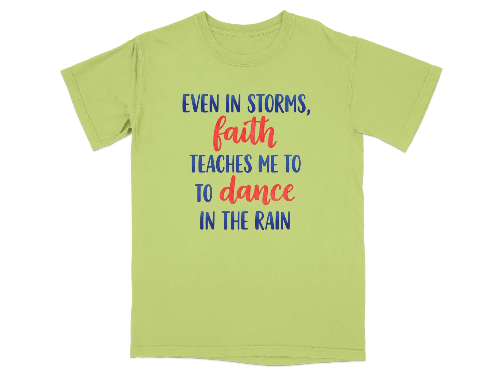 Light green t-shirt with blue and red text "Even in storms, faith teaches me to dance in the rain."