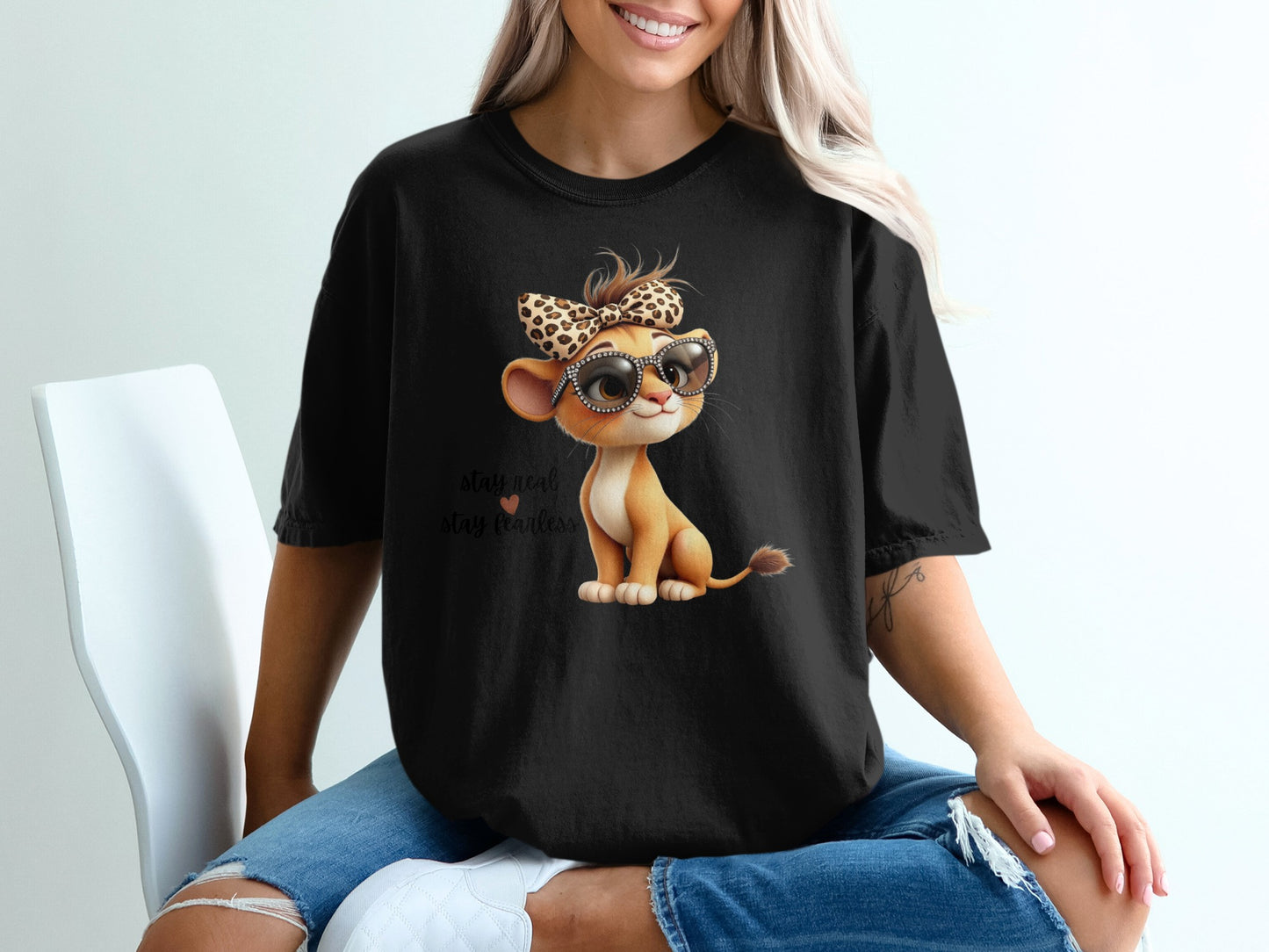 Black t-shirt with a lion cub wearing sunglasses and a leopard print bow.