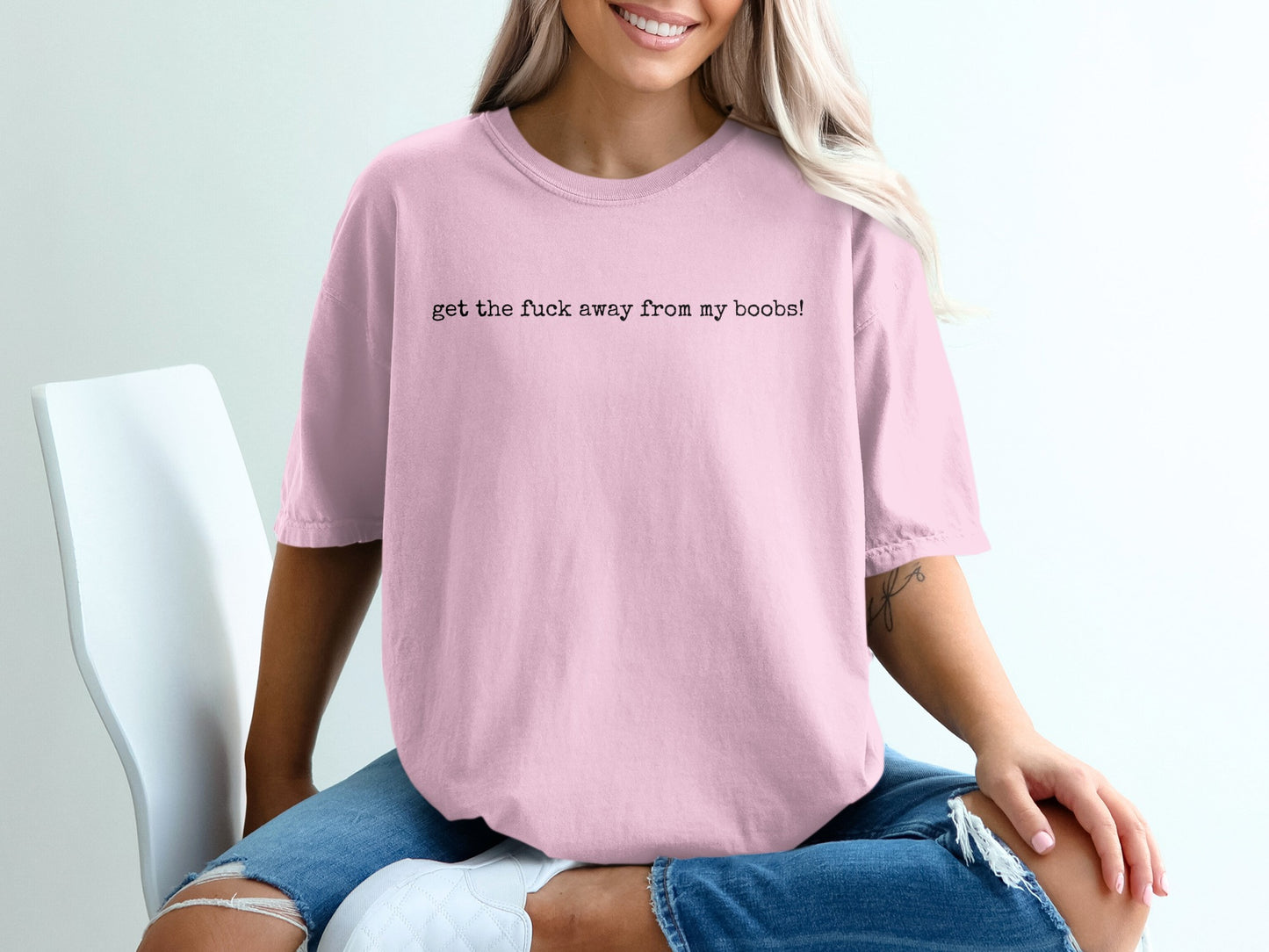 Pink t-shirt with "get the fuck away from my boobs!" text, worn by a woman.