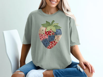 T-shirt with a patchwork strawberry design on a person sitting.