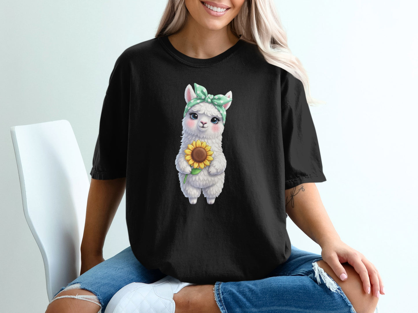 Black t-shirt with a cartoon llama holding a sunflower.