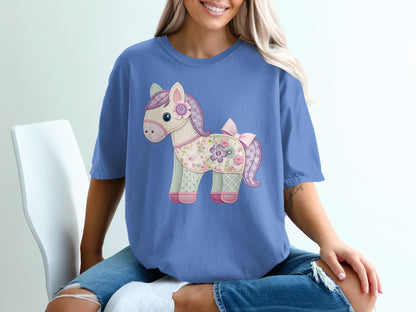 T-shirt with a pastel patchwork horse graphic wearing a flower and bow.