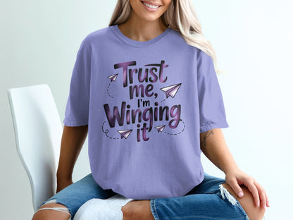 Purple t-shirt with "Trust me, I'm Winging it" text and paper airplanes.