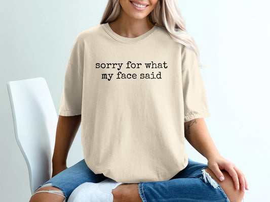 Cream t-shirt with black text that reads "sorry for what my face said".