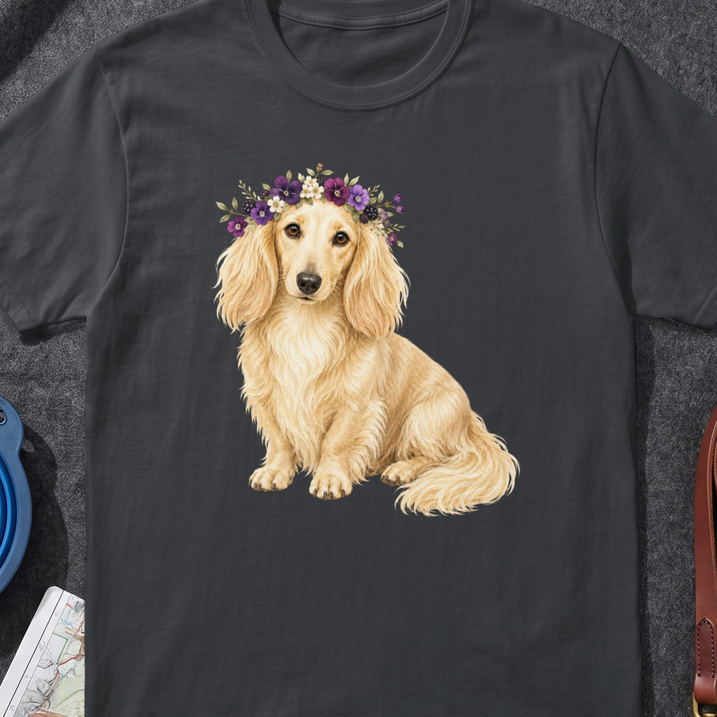 Dachshund wearing a floral crown sits on a dark grey t-shirt.