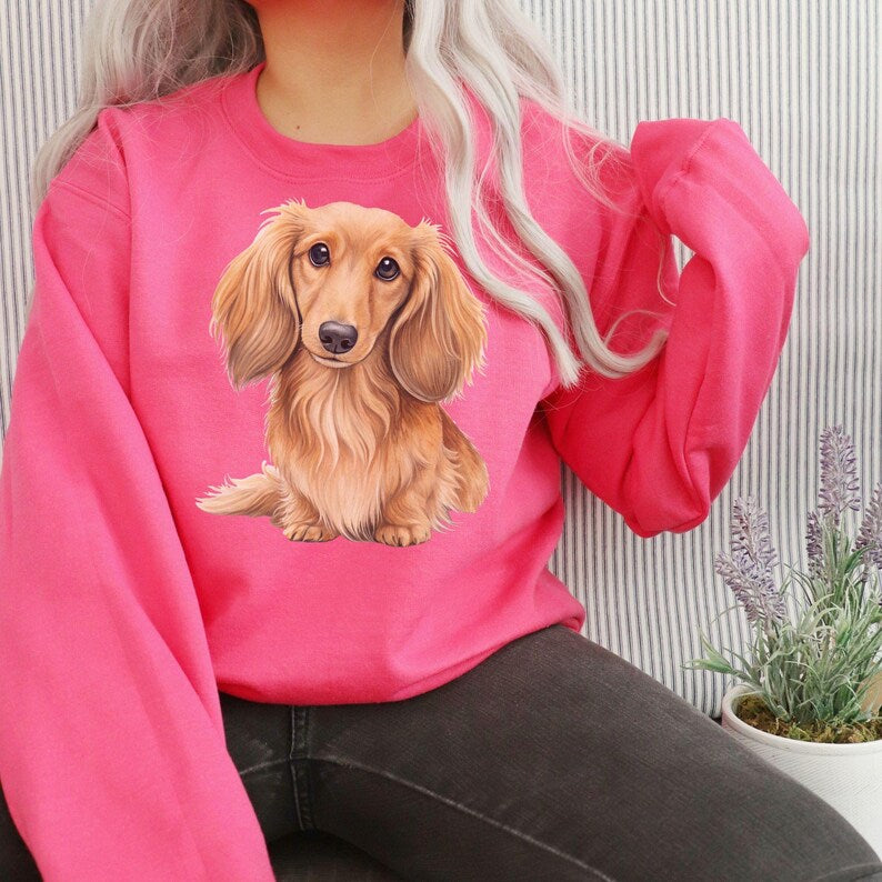 Long-haired dachshund watercolor design on a pink sweatshirt