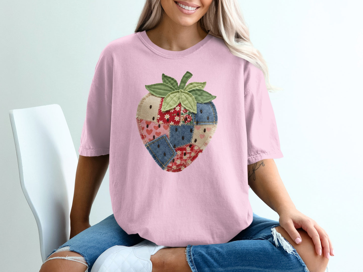 Pink t-shirt with a patchwork strawberry graphic.