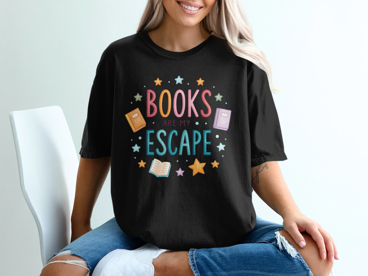 Black t-shirt with "Books are my escape" and colorful stars and books design.