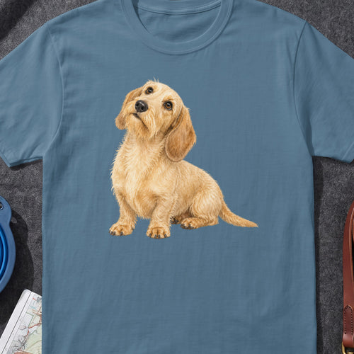 Watercolor illustration of a fluffy tan dog sitting and looking up on a blue t-shirt.