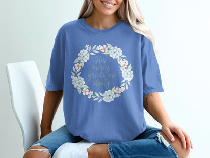 Blue t-shirt with floral wreath and text "His mercy greets me daily".