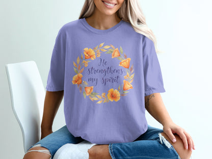 Purple t-shirt with floral wreath and "He strengthens my spirit" text.