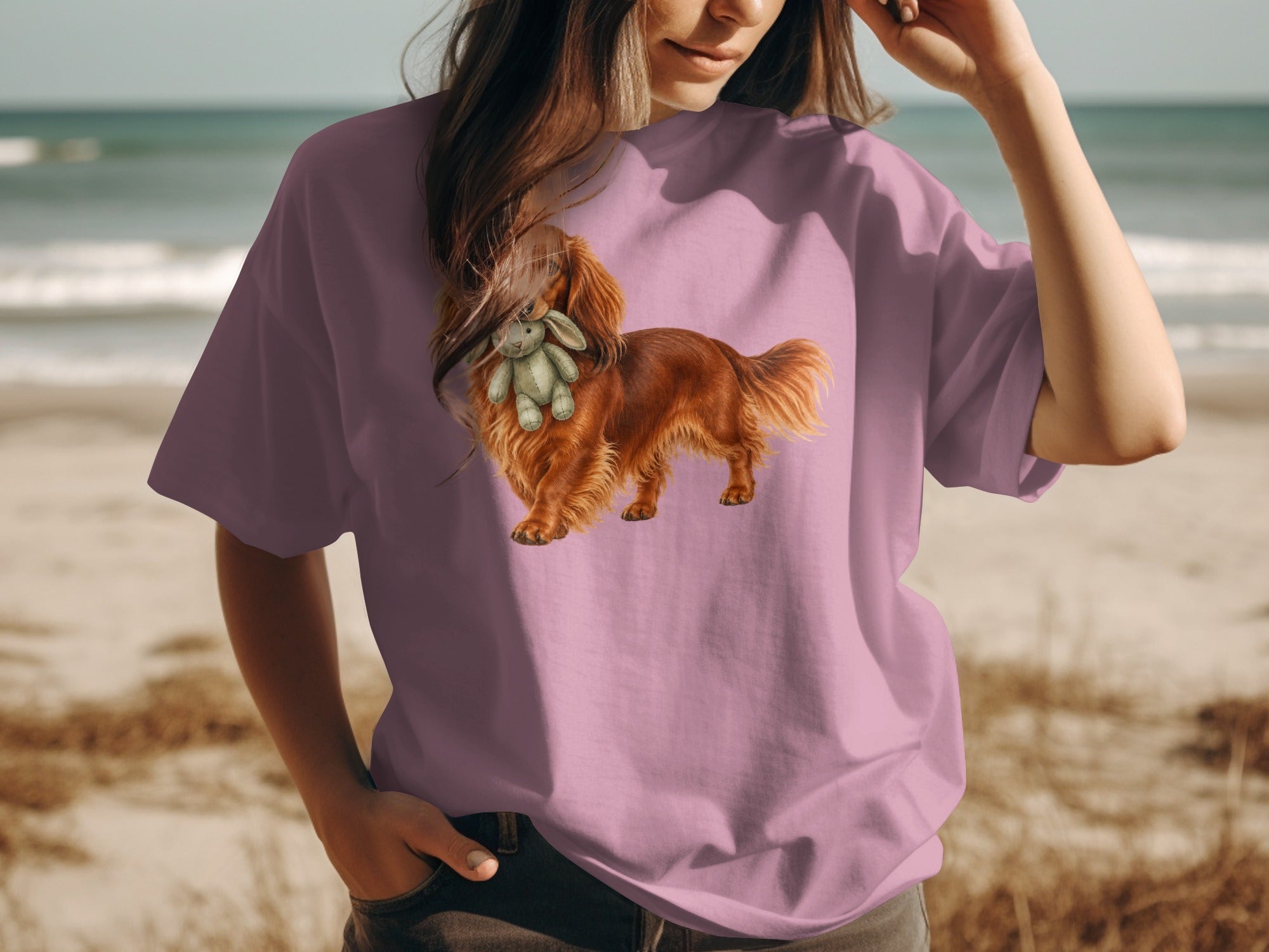 Pink t-shirt with illustration of a brown dog holding a stuffed bunny.