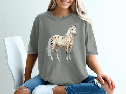 Appaloosa horse illustration on a gray t-shirt worn by a seated person.