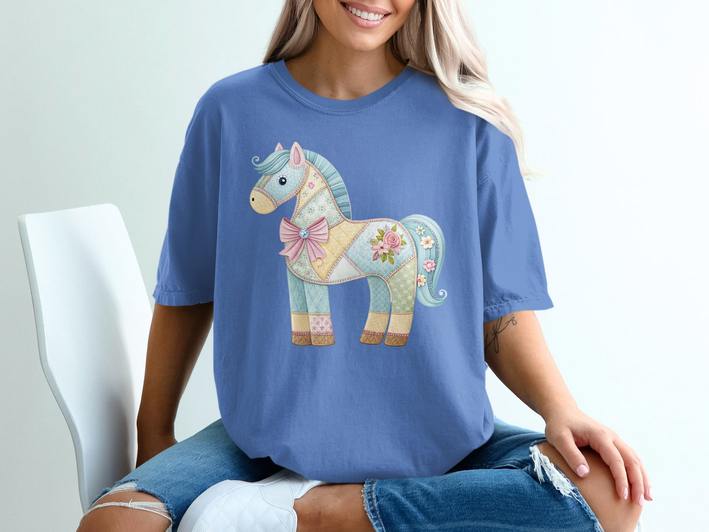 Blue t-shirt with a pastel patchwork horse graphic and pink bow.