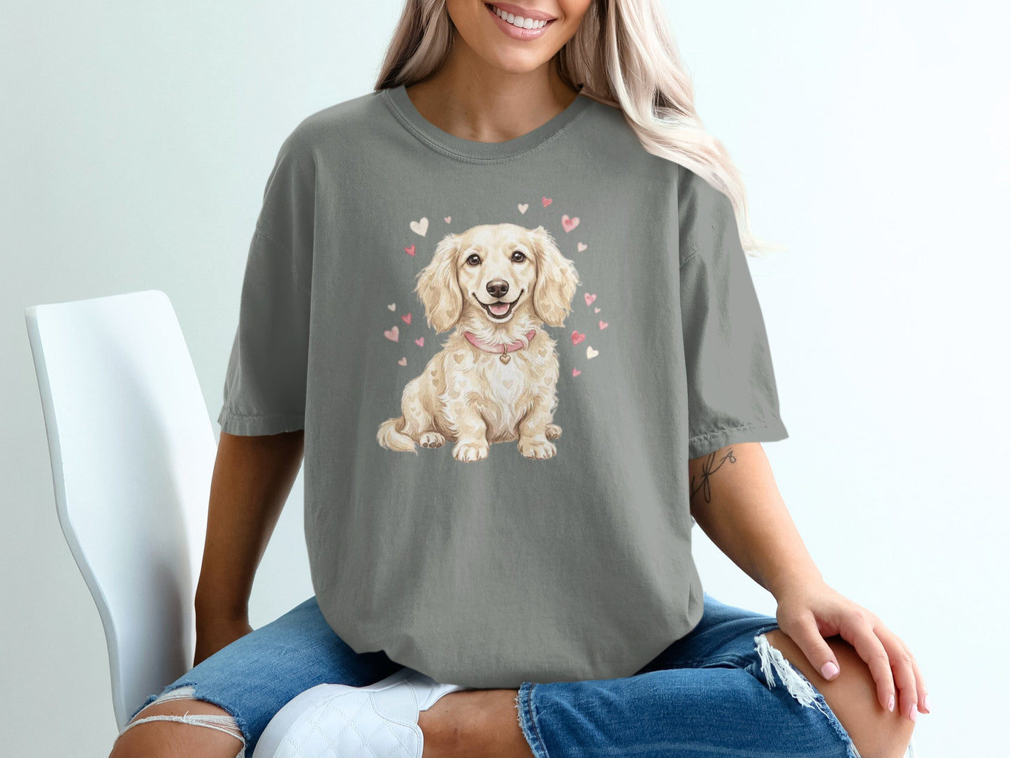 Cream dachshund with pink hearts on a grey t-shirt.
