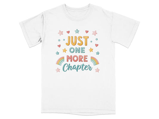 White t-shirt with "JUST ONE MORE CHAPTER" in colorful text and rainbow stars.