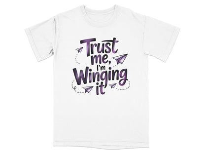 White t-shirt with "Trust me, I'm winging it!" text and paper airplanes.
