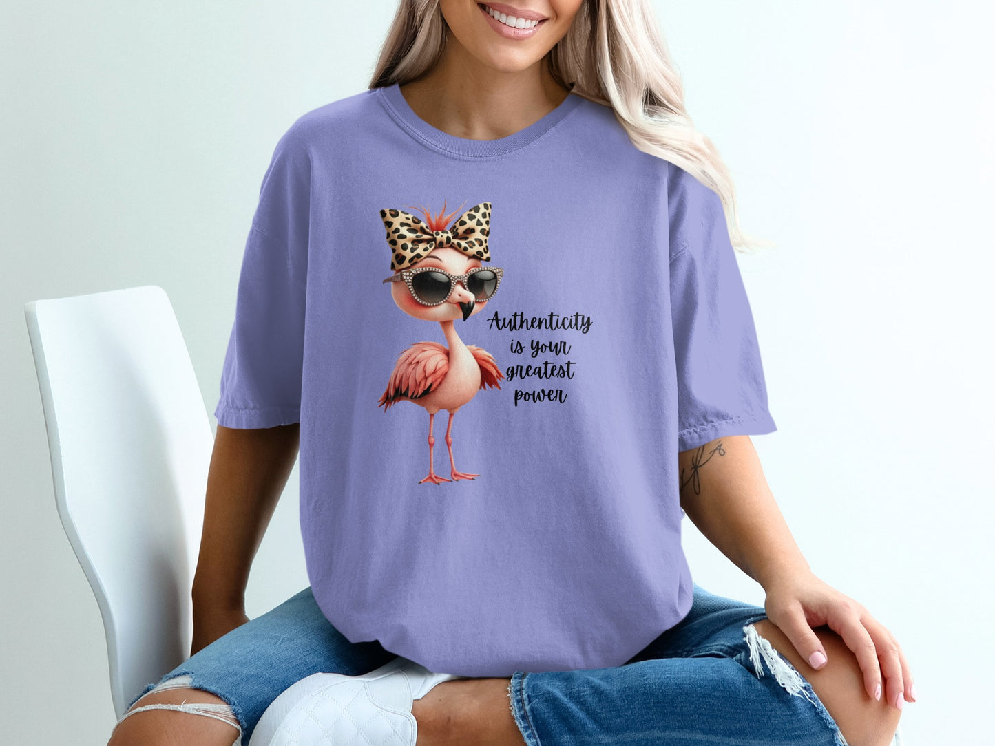 Flamingo graphic with leopard print bow and sunglasses on purple t-shirt.