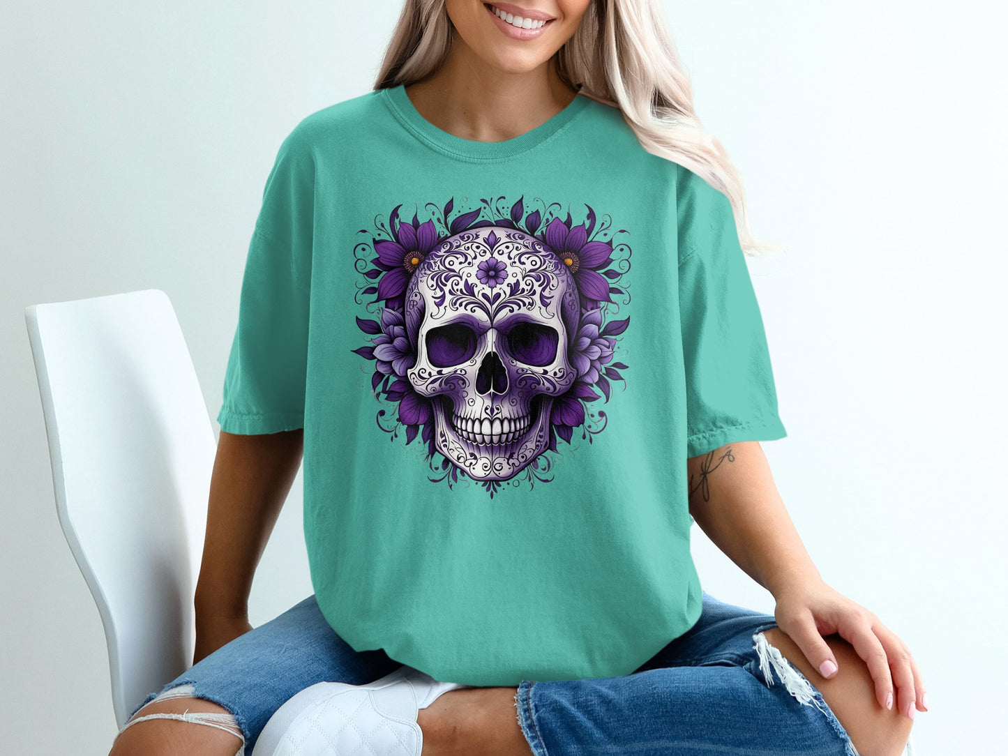 Teal t-shirt with a purple floral skull design on the front.