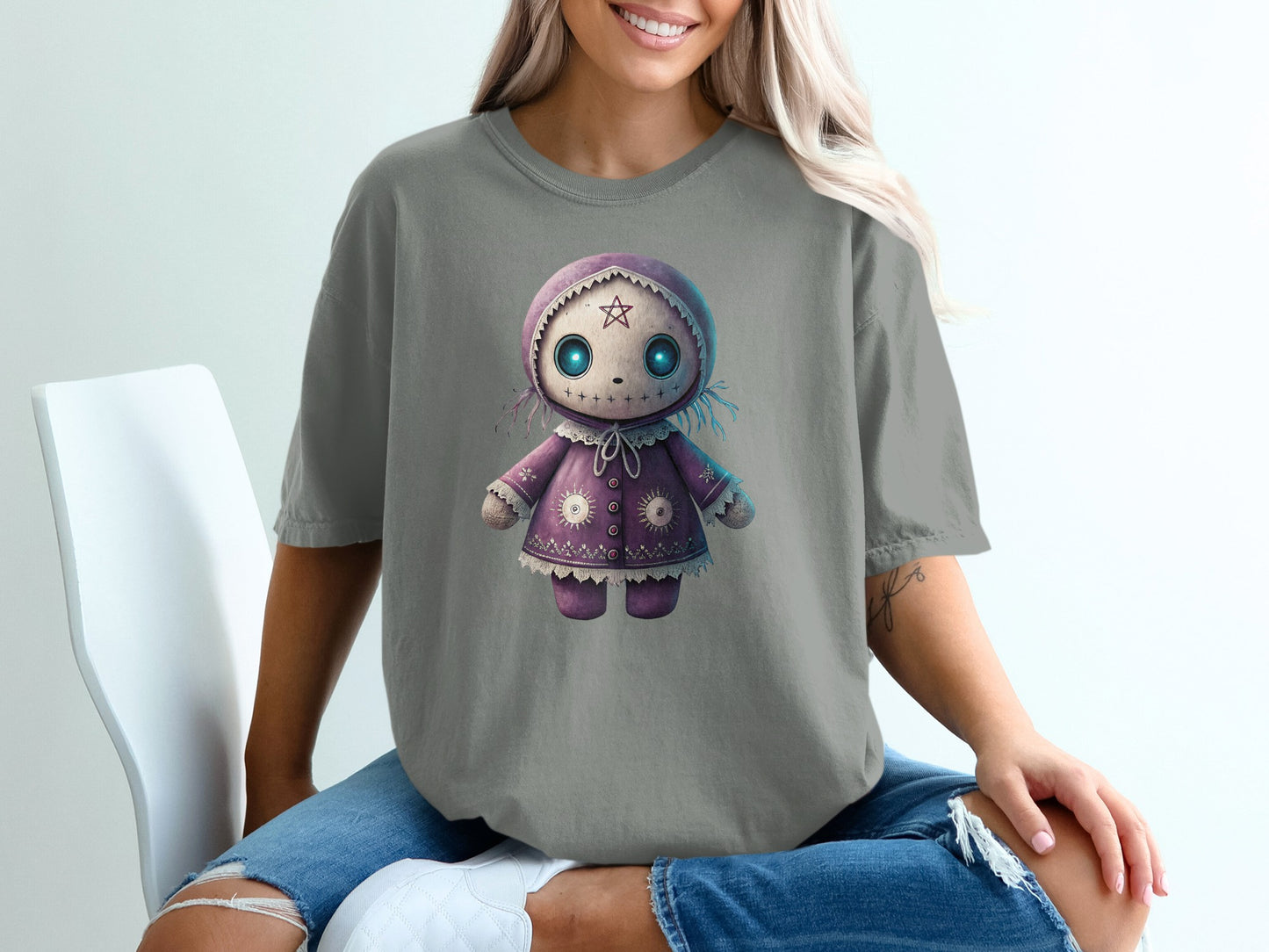Gray t-shirt with a purple doll design, featuring blue eyes and stars.