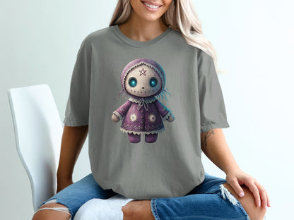 Gray t-shirt with a purple doll design, featuring blue eyes and stars.