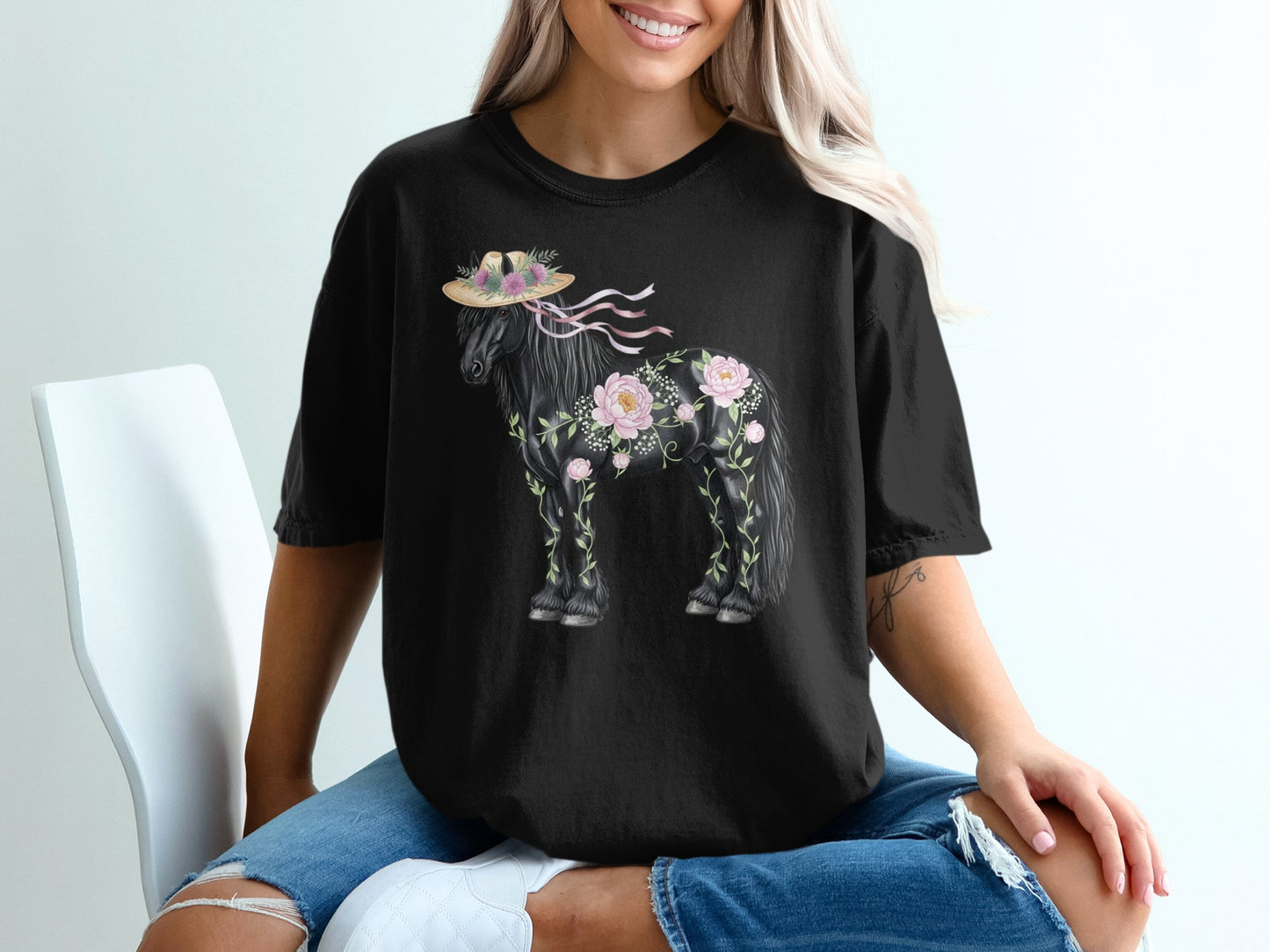 Black t-shirt with a floral horse graphic wearing a straw hat.