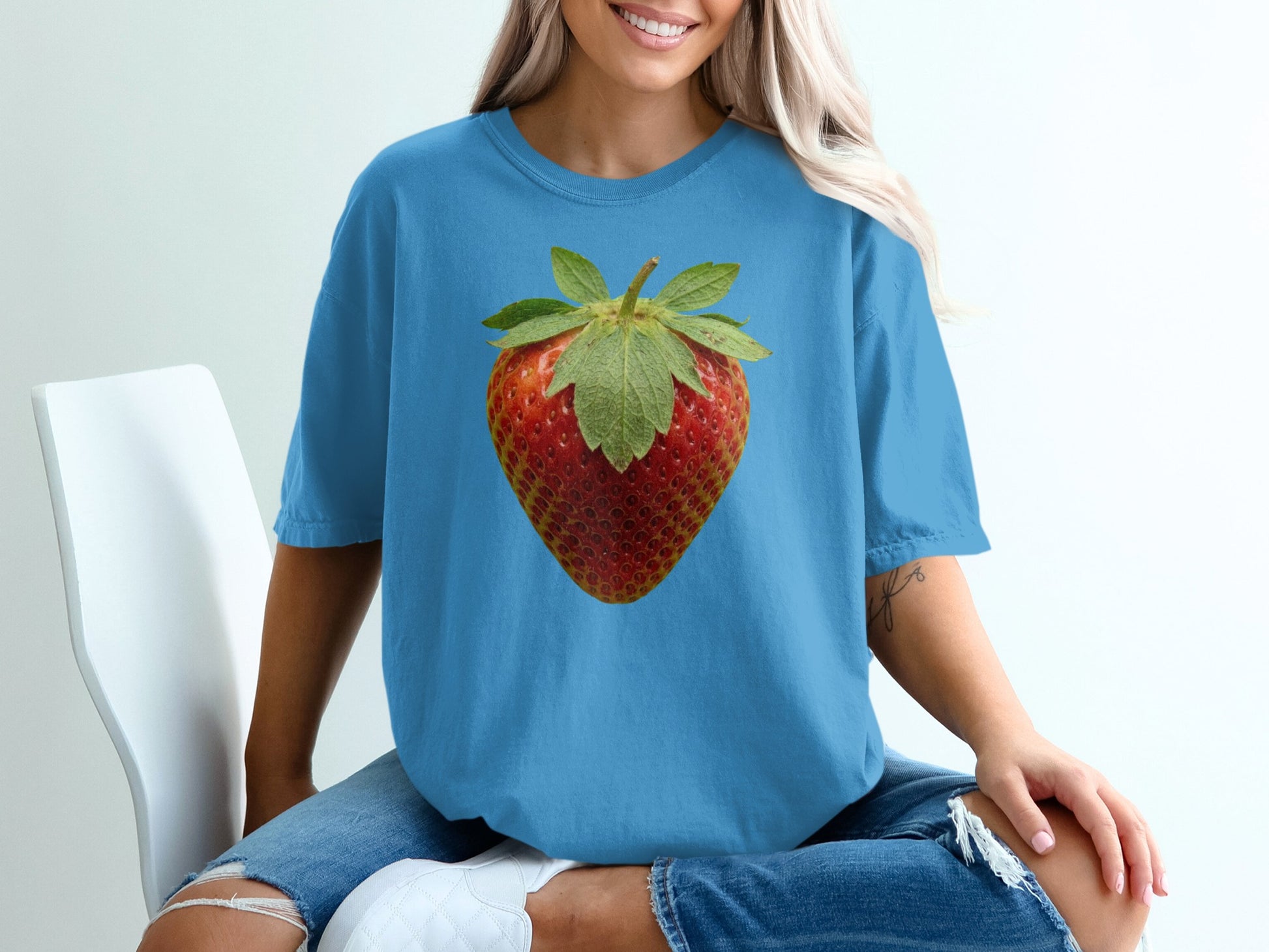 Blue t-shirt with a large, realistic strawberry graphic centered on the chest.