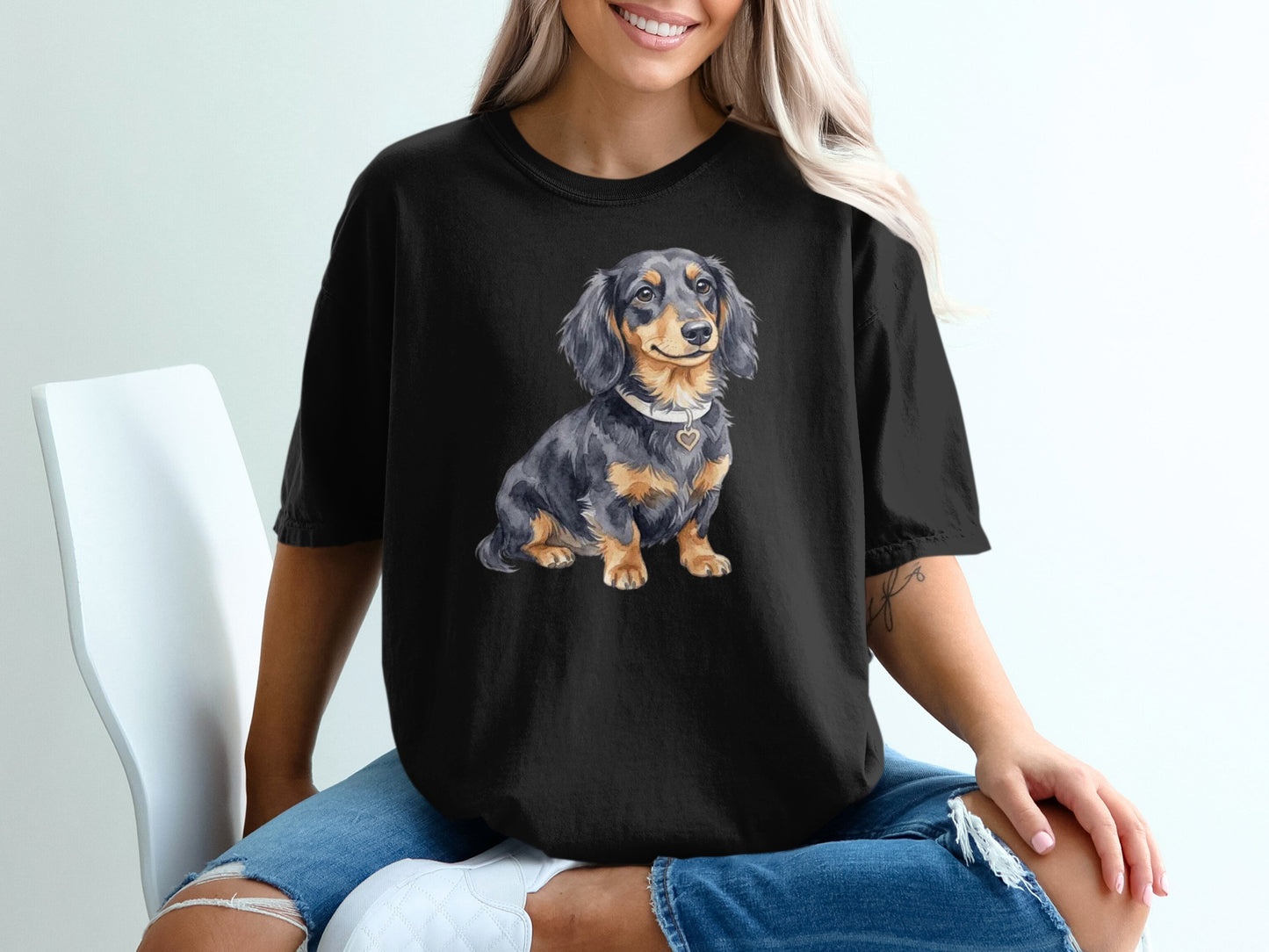 Black t-shirt with a watercolor illustration of a dachshund wearing a heart pendant.