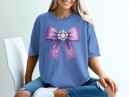 Purple bow with rhinestones and pearls on a t-shirt.