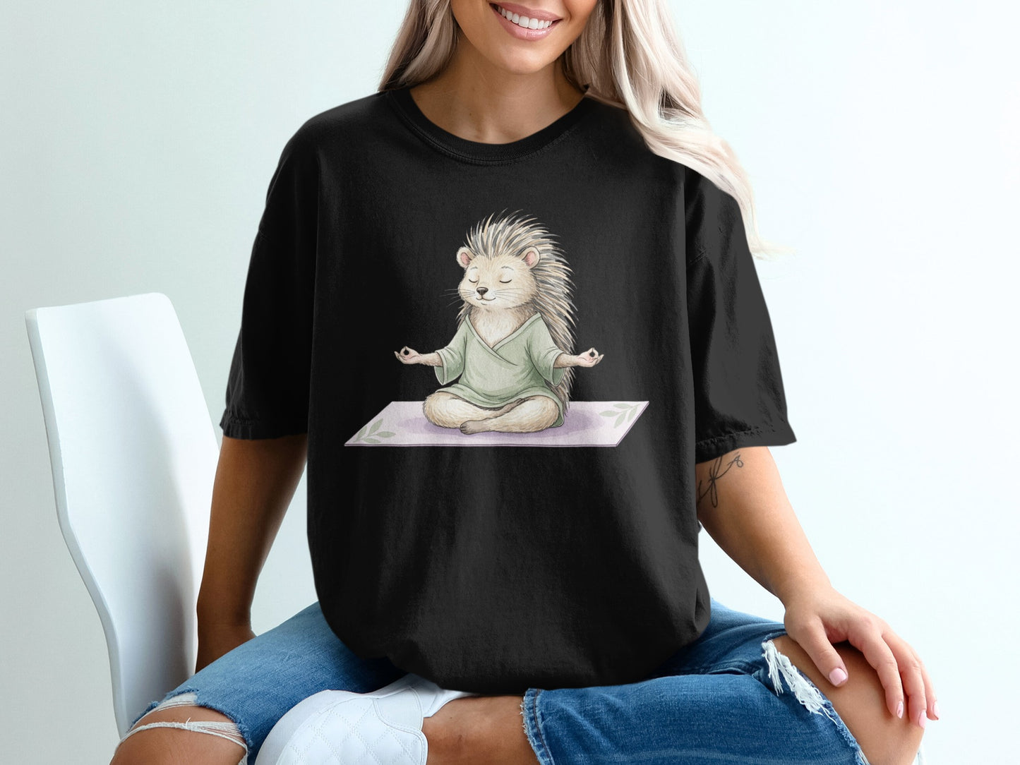 Black t-shirt with a meditating hedgehog graphic on a yoga mat.