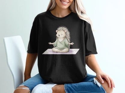 Black t-shirt with a meditating hedgehog graphic on a yoga mat.