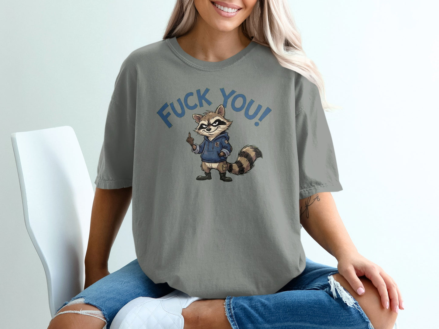 T-shirt featuring a cartoon raccoon wearing a hoodie with "Fuck You!" text.