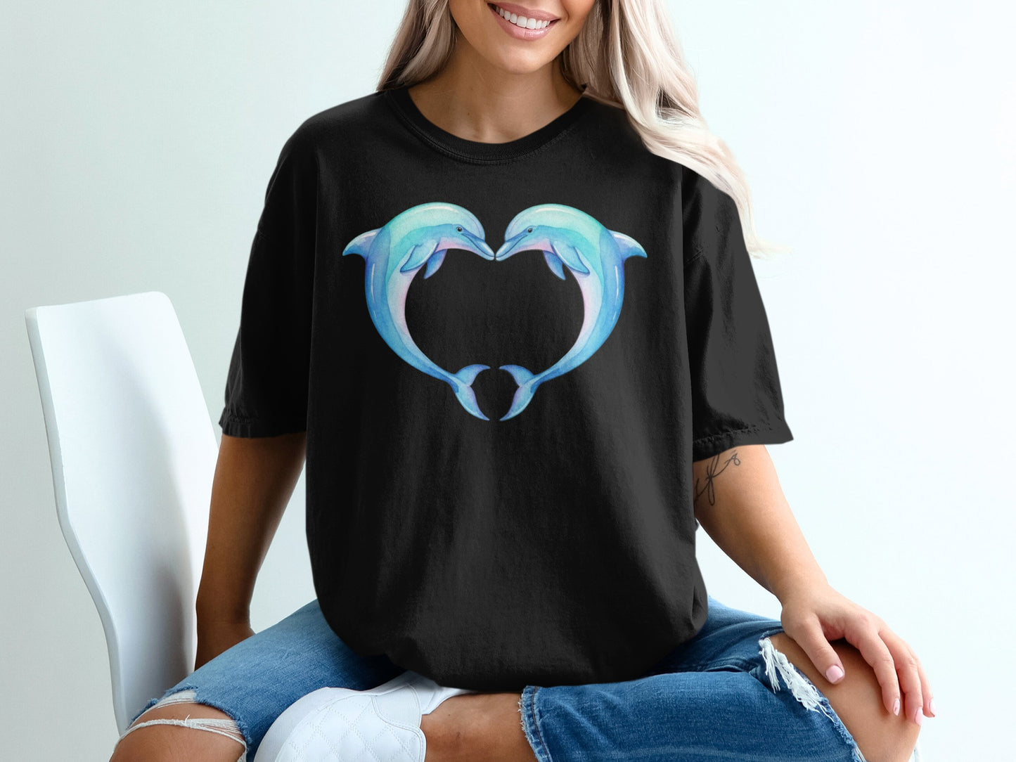 Black t-shirt with two watercolor dolphins forming a heart shape.