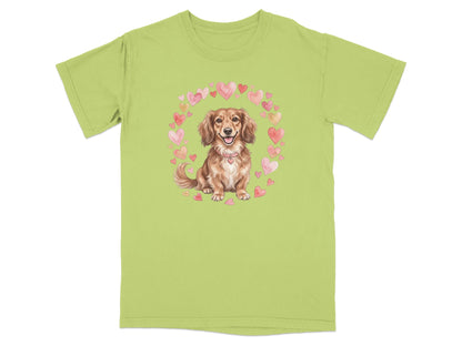 Dachshund wearing a pink collar surrounded by a heart wreath on a light green t-shirt.