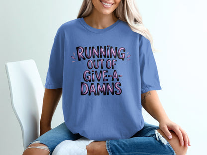 Blue t-shirt with "RUNNING OUT OF GIVE-A-DAMNS" in pink and purple text.